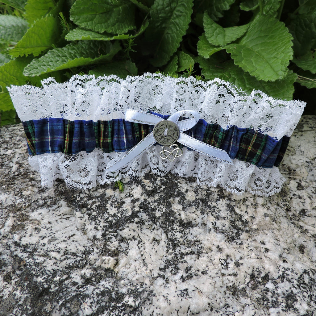 Garter with lace and Nova Scotia Tartan on a stone surface with green leaves in the background