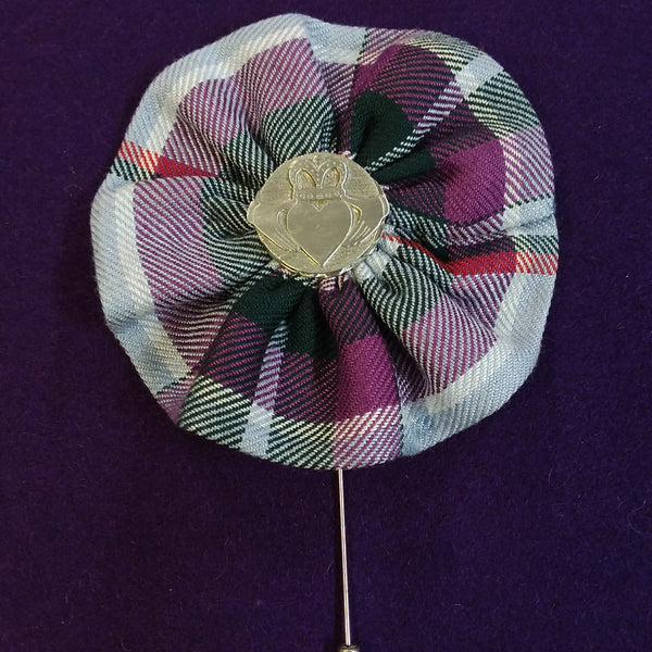 Plaid fabric flower brooch with a metal clasp on a purple background
